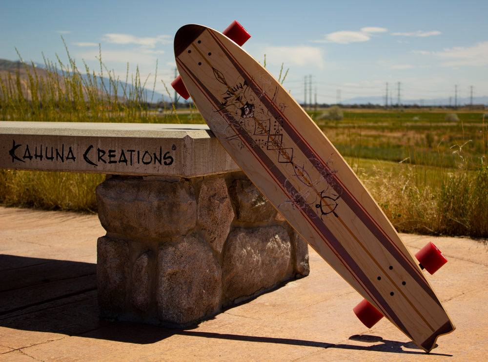 Kahuna Creations fishtail longboard leaning on a bench