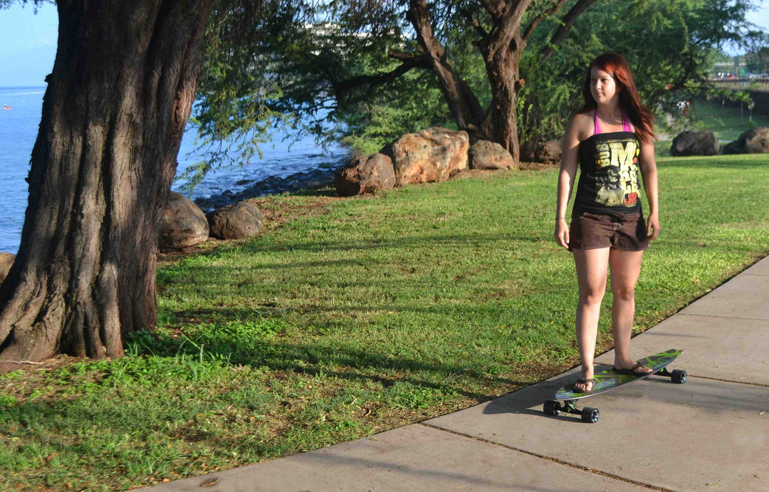 Woman riding Kahuna Creations Haka Neo longboard.